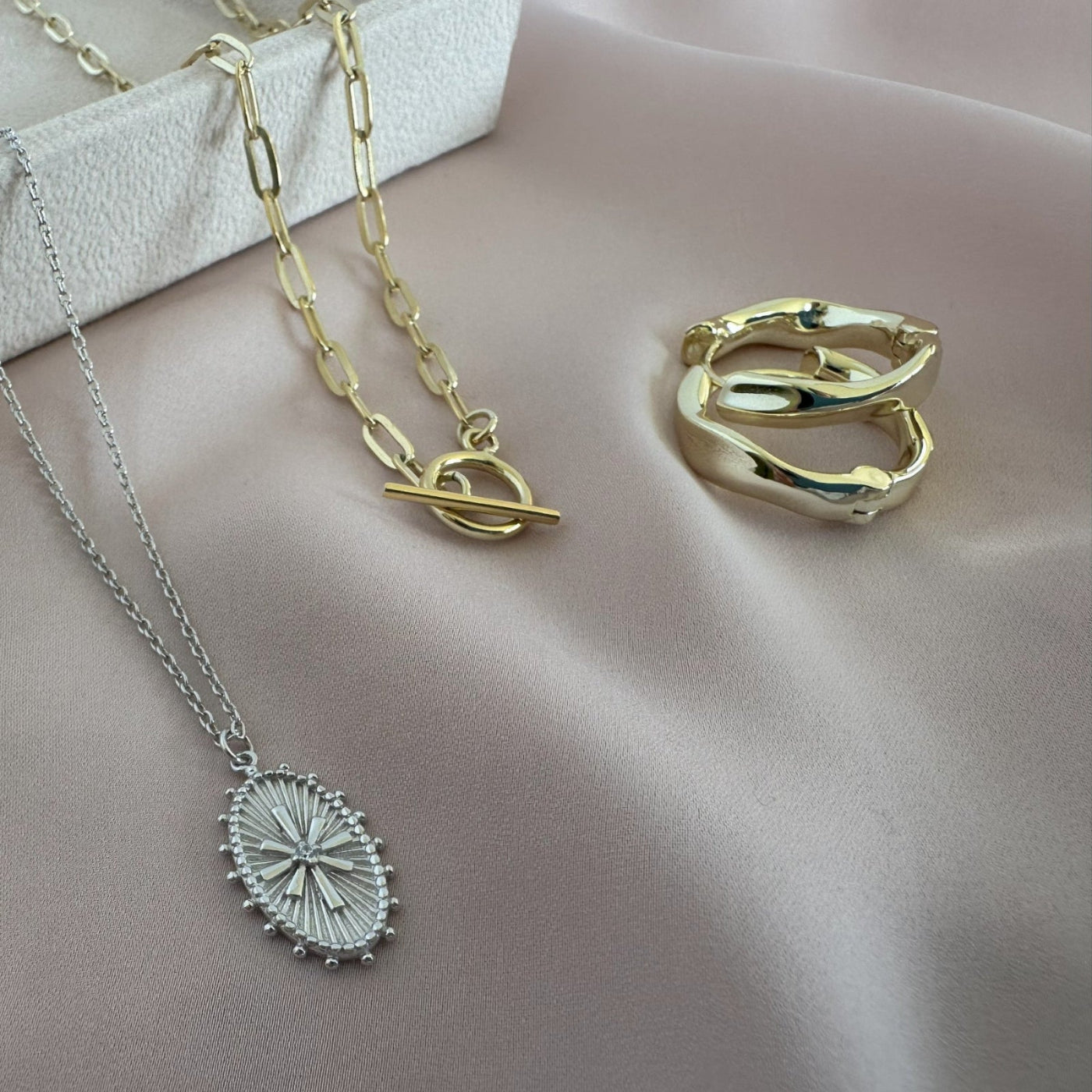 stylish jewellery laid on blush colour fabric