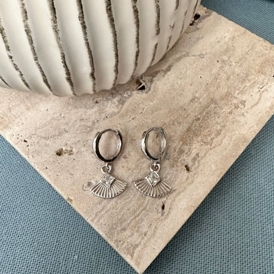 fan charm silver earrings on terazzo tile