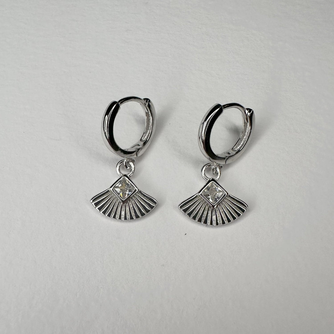 pair of art deco inspired fan geometric silver huggies on white background