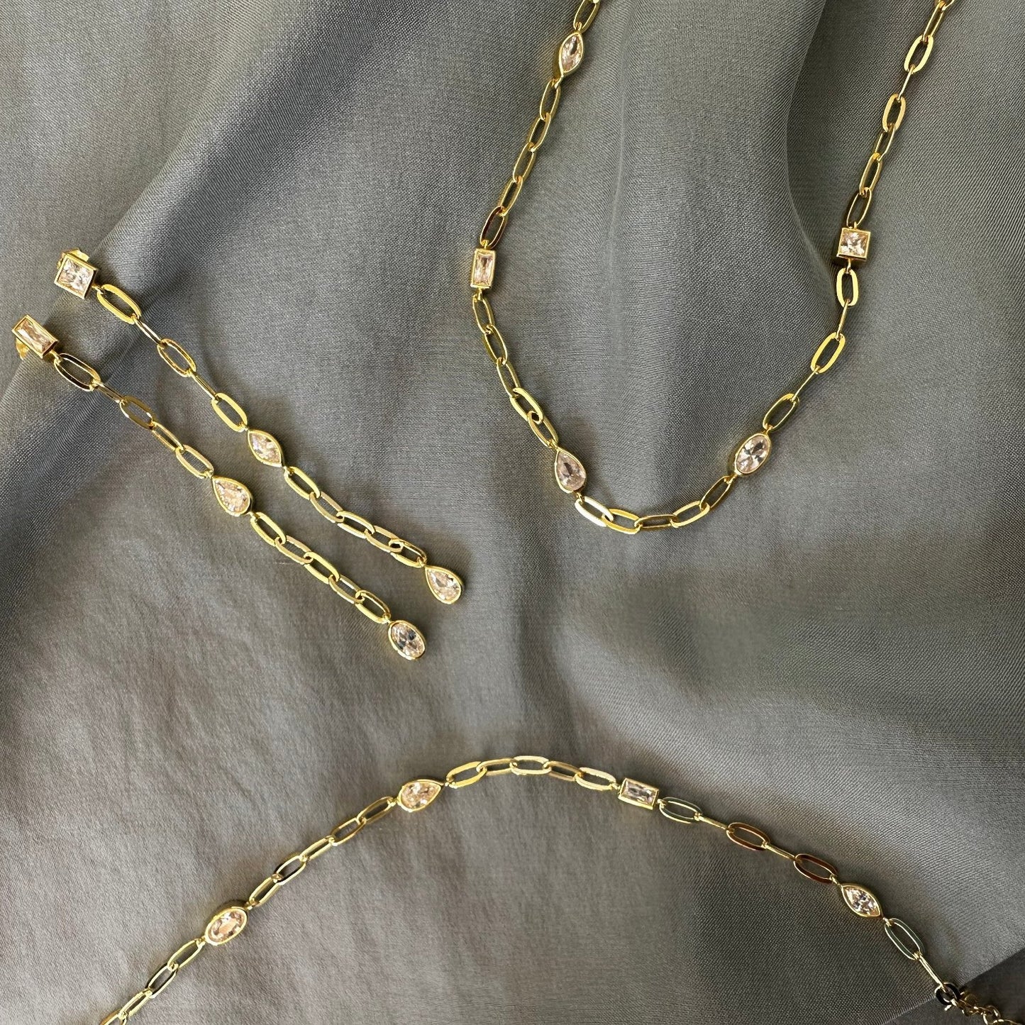 old earrings and chains on grey ground