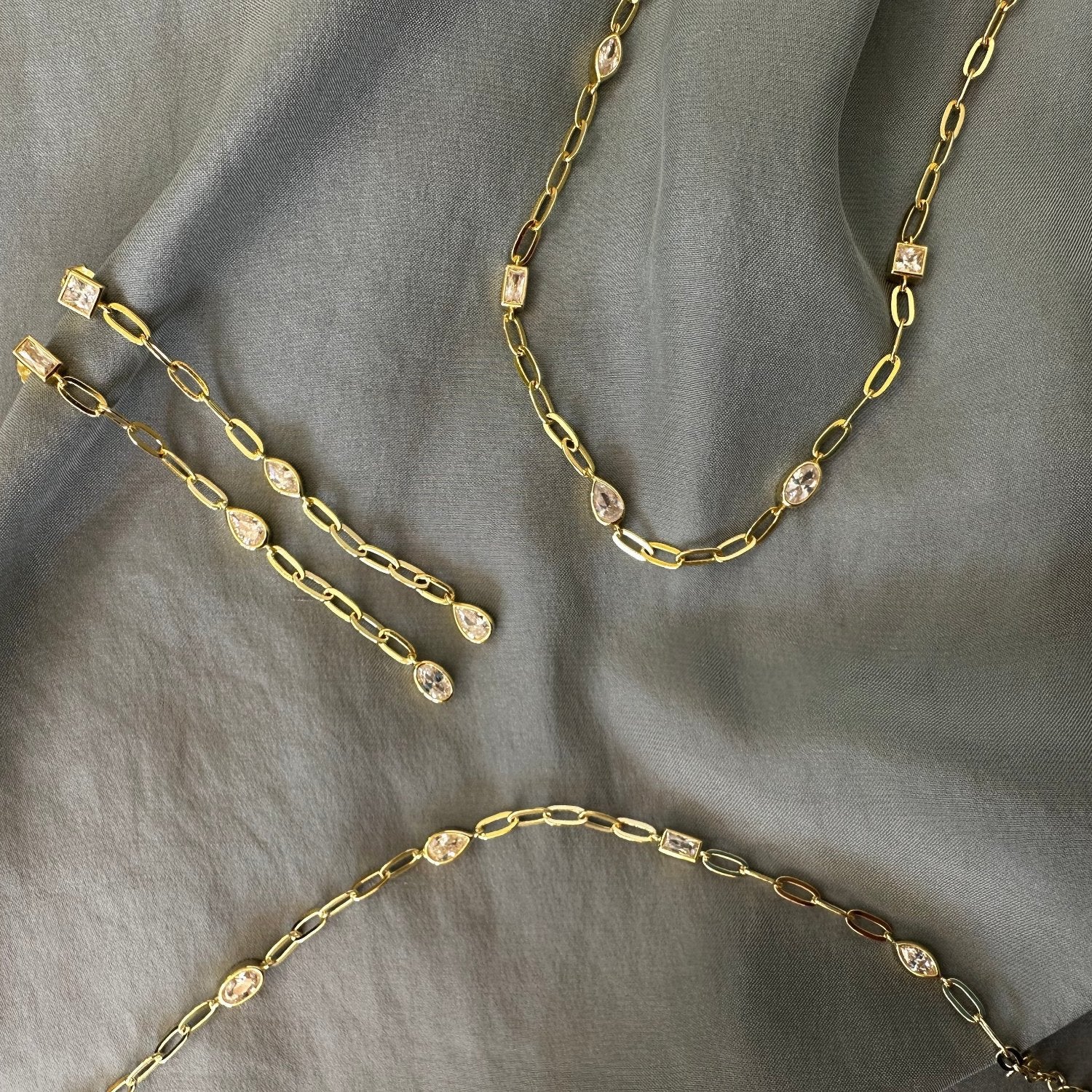 old earrings and chains on grey ground
