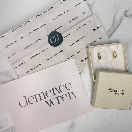 packaging for clemence wren, featuring a gift box, tissue papr, thank you card laid out on marble ground
