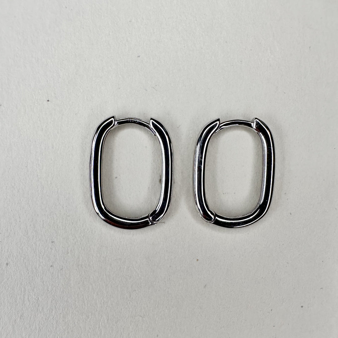 Silver oval hopps aid flat on white ground