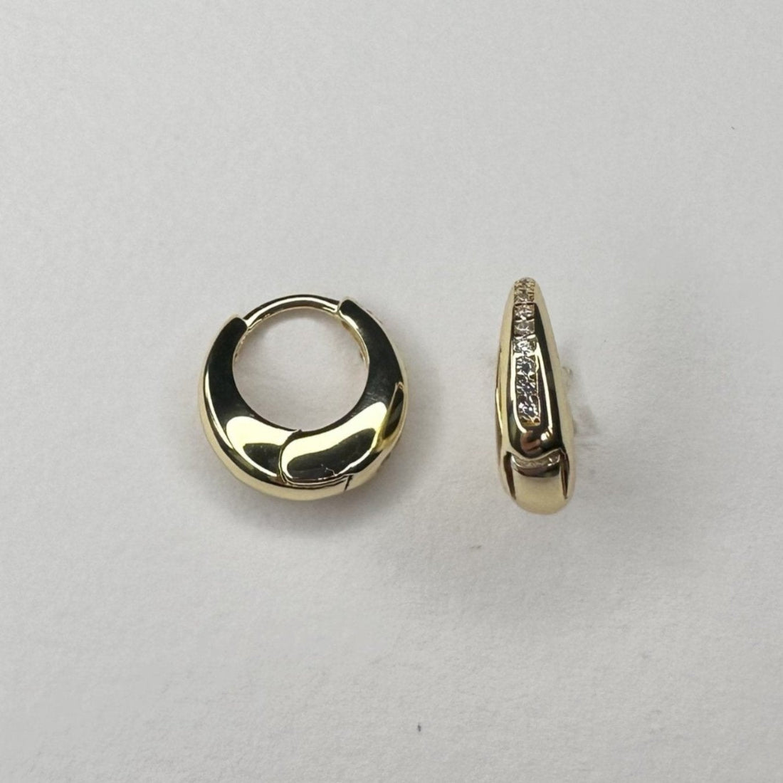dome shaped huggies with channel set gemstones laid on white ground