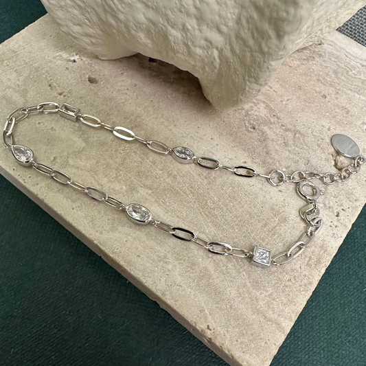 Silver bracelet with CZ stones of different shapes on stone background