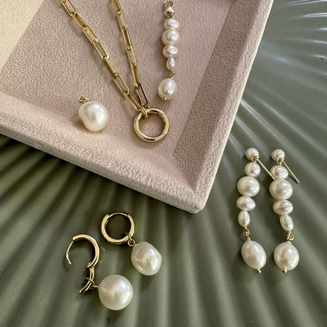 Modern Natural Freshwater Pearl jewelry set including necklace, earrings, and hoop earrings on a textured surface.
