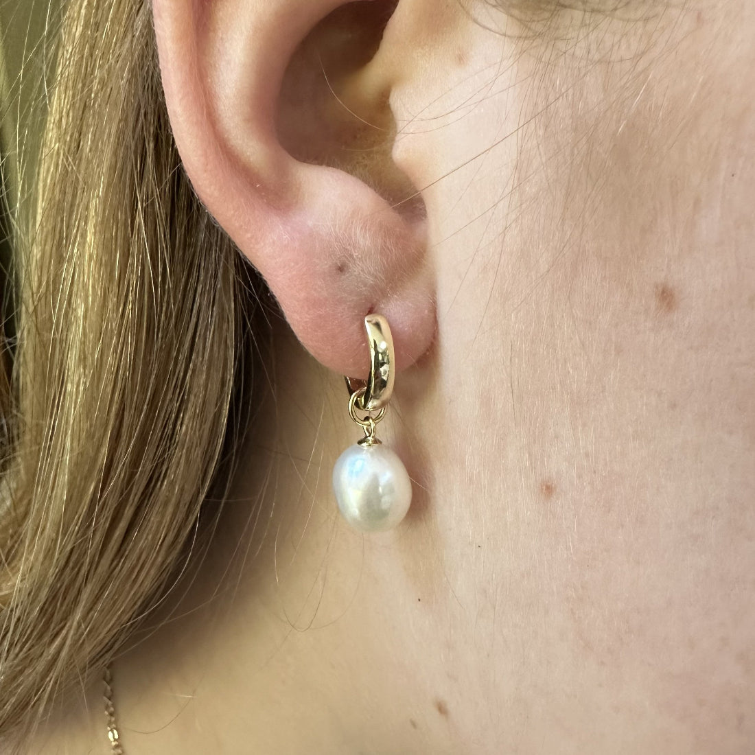 Chunky statement Pearl earring worn on an ear with a close-up view