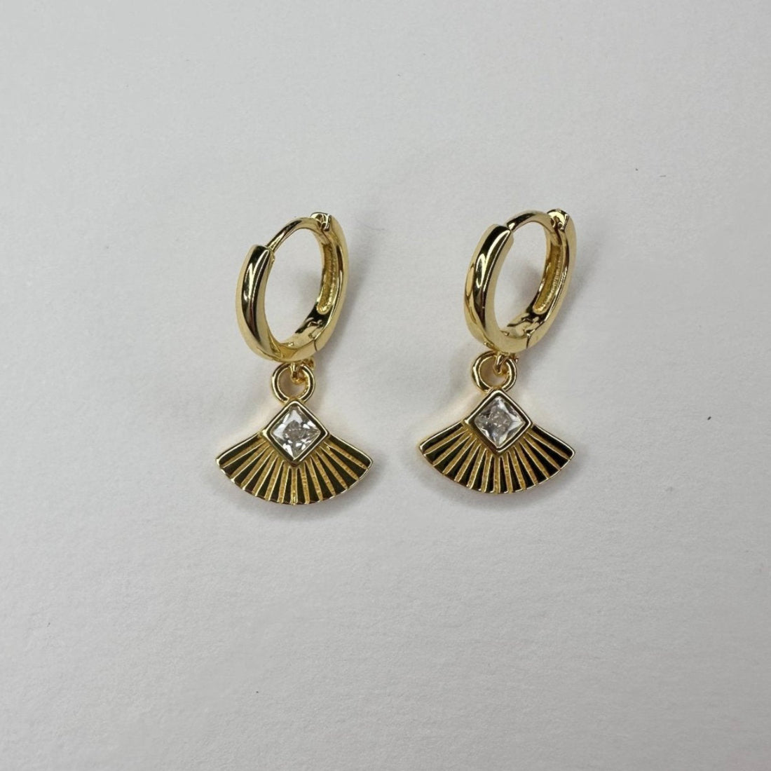 a pair of art deco inspired fan charm huggies on white background