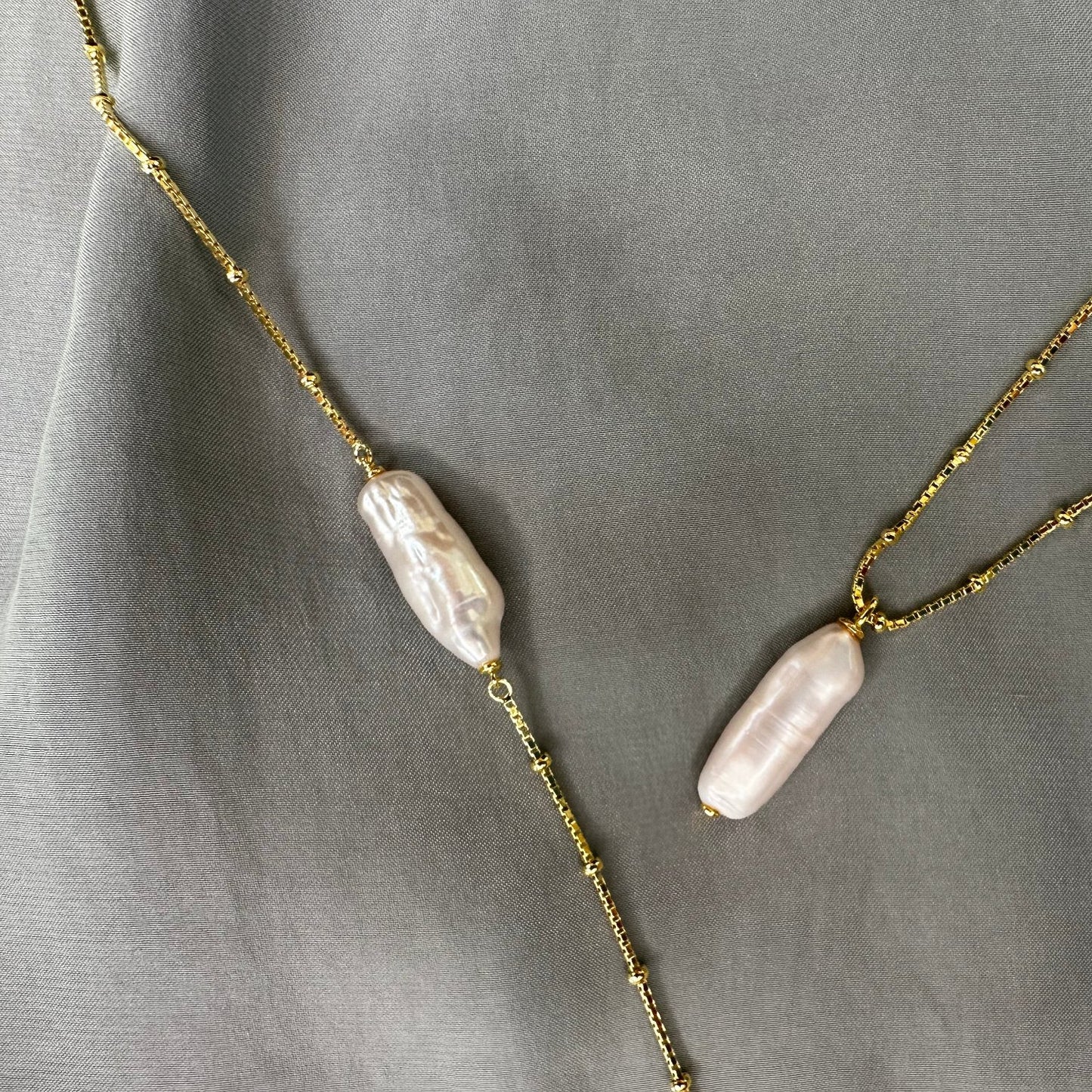 Lustrous pearl gold pendant and bracelet on grey ground