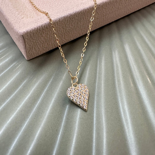 Heart-shaped pendant necklace on a textured surface
