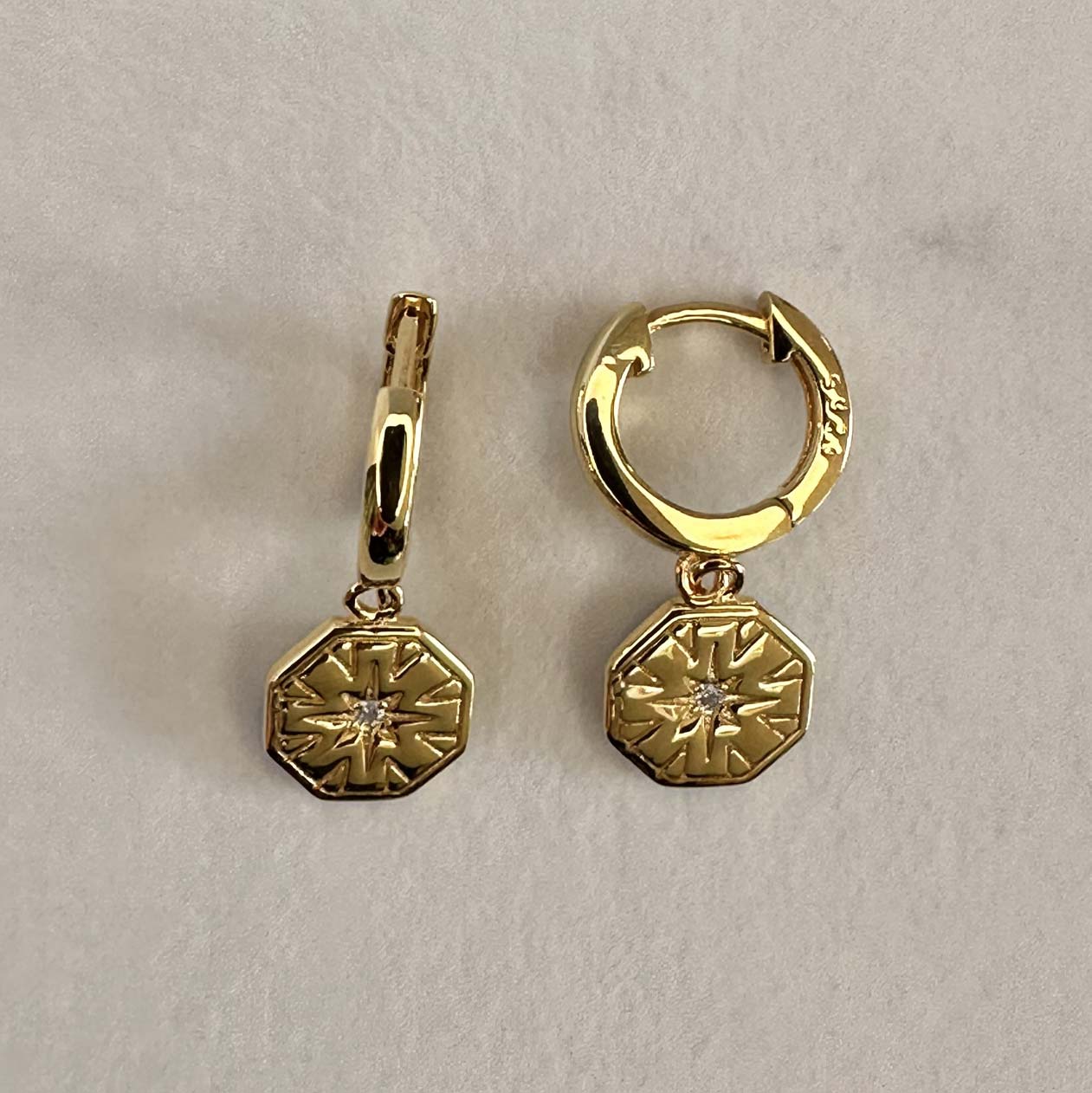 hexagon charm huggie earrings on cream ground