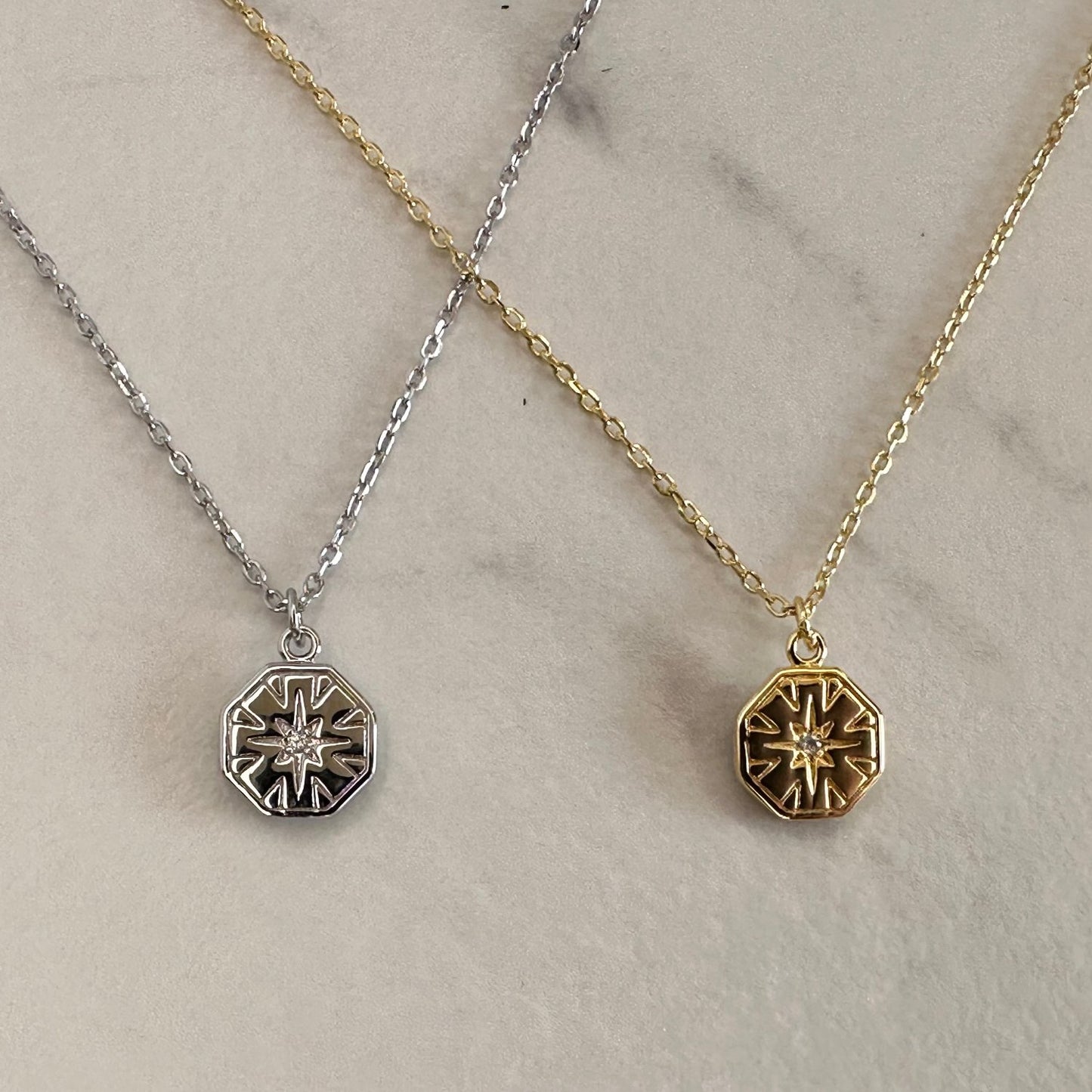 2 necklaces in silver and gold on grey ground