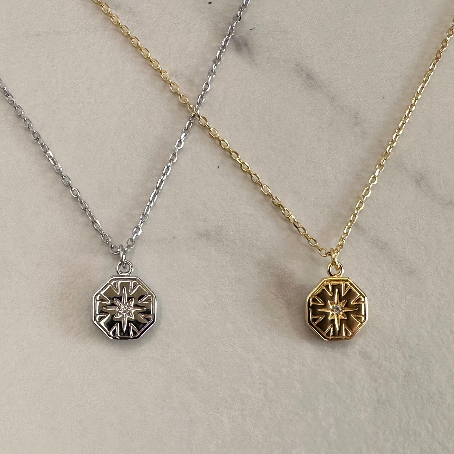 2 necklaces in silver and gold on grey ground