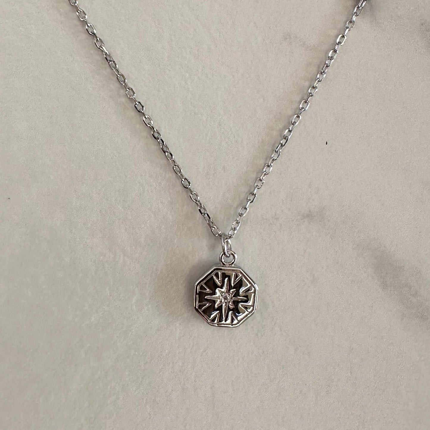 Silver necklace on grey ground