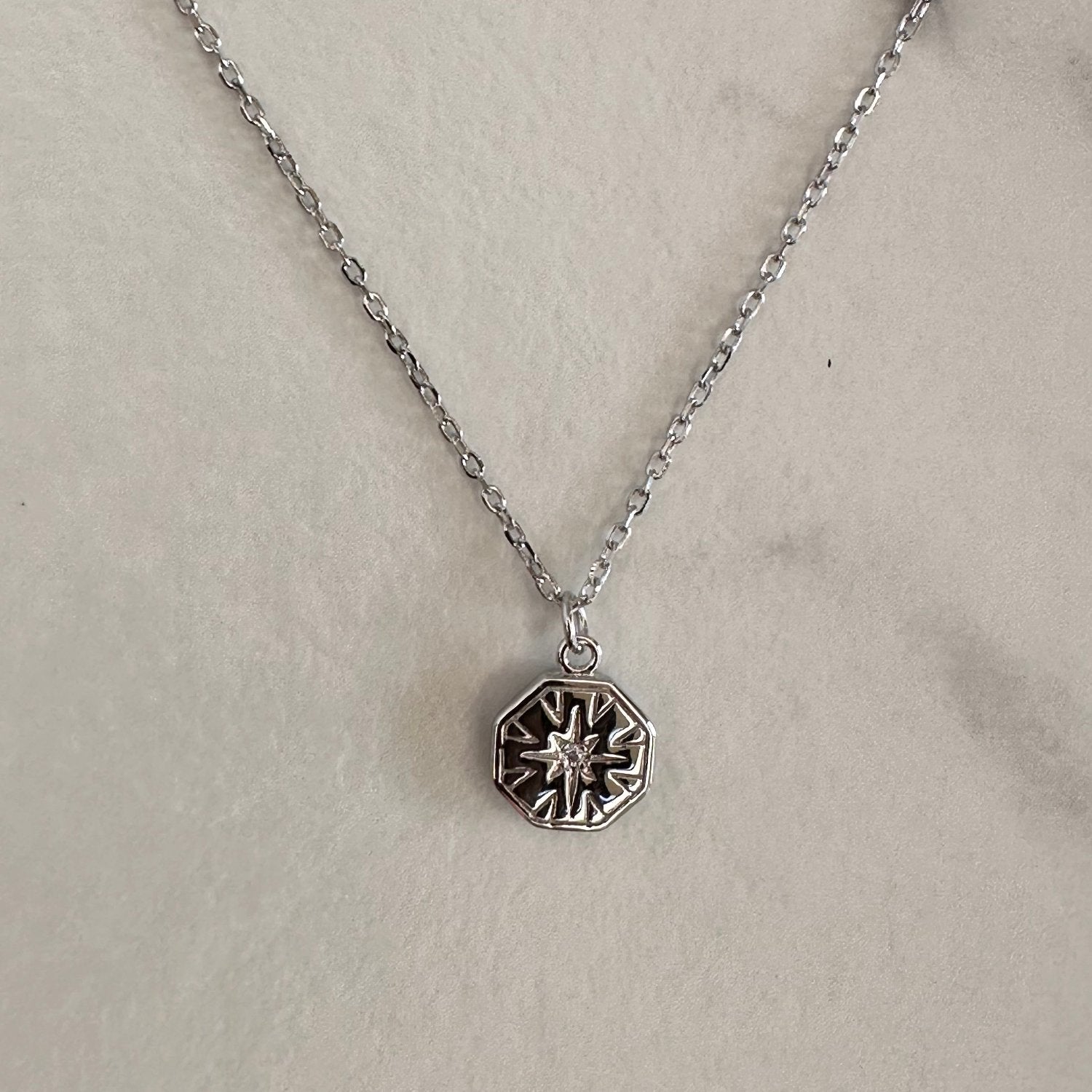 Silver necklace on grey ground