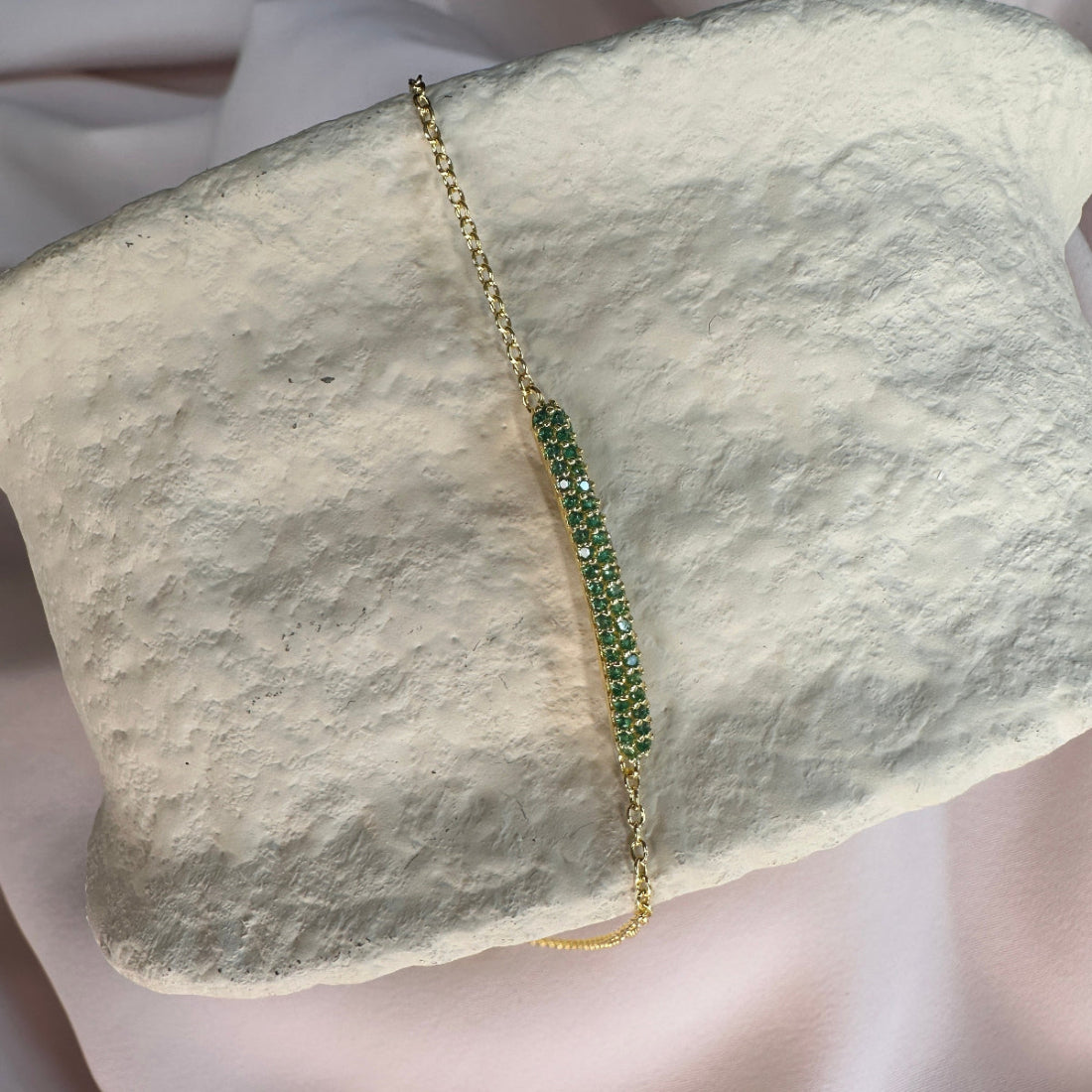 Green beaded bracelet on a textured stone surface