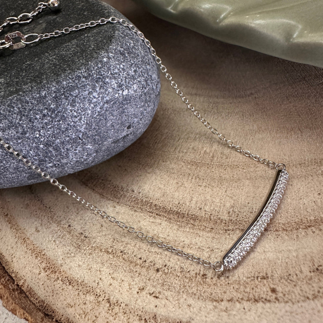 Silver bracelet with pretty white crystal setting on a stone surface