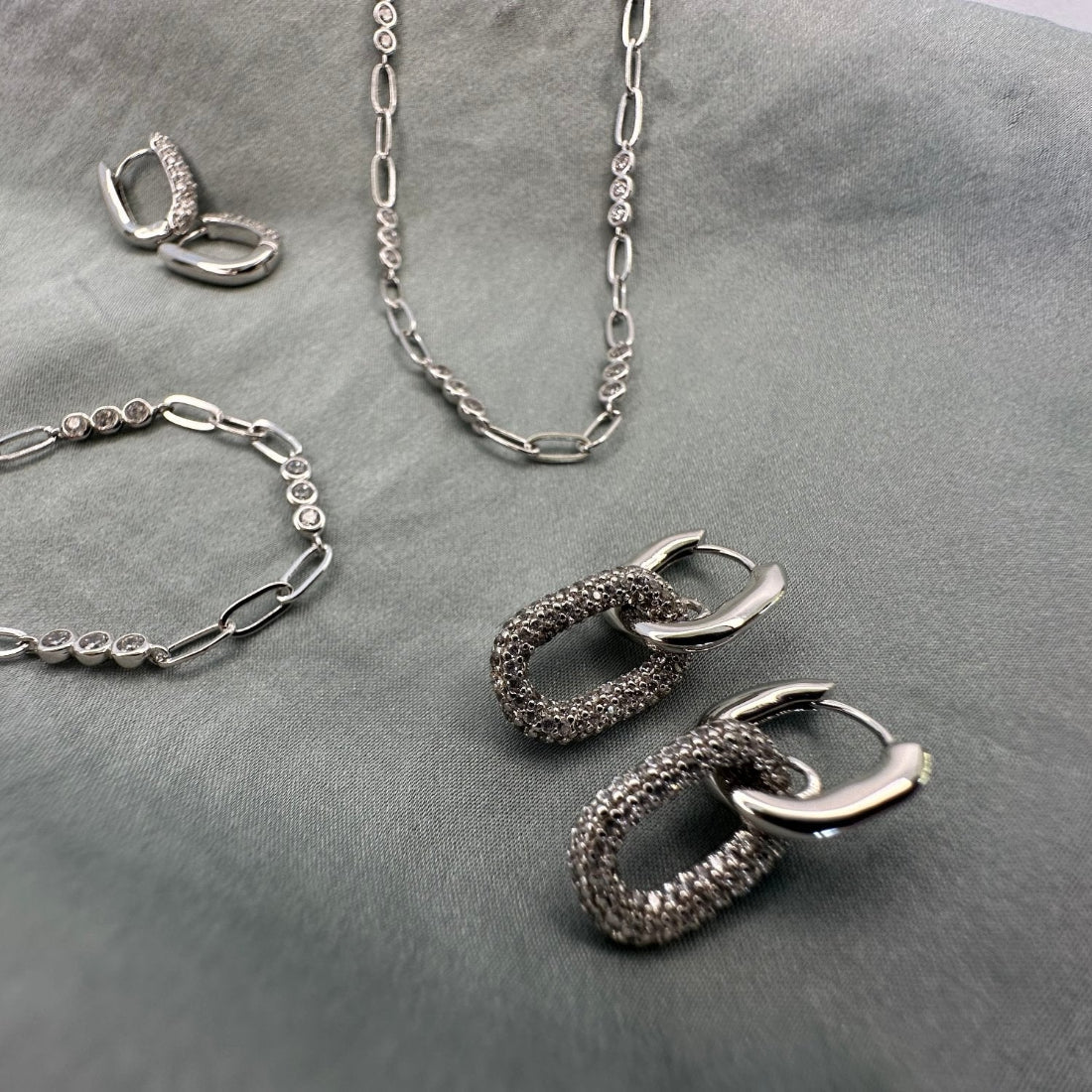 a collection of modern silver jewellery using gemstones and trending paperclip chains