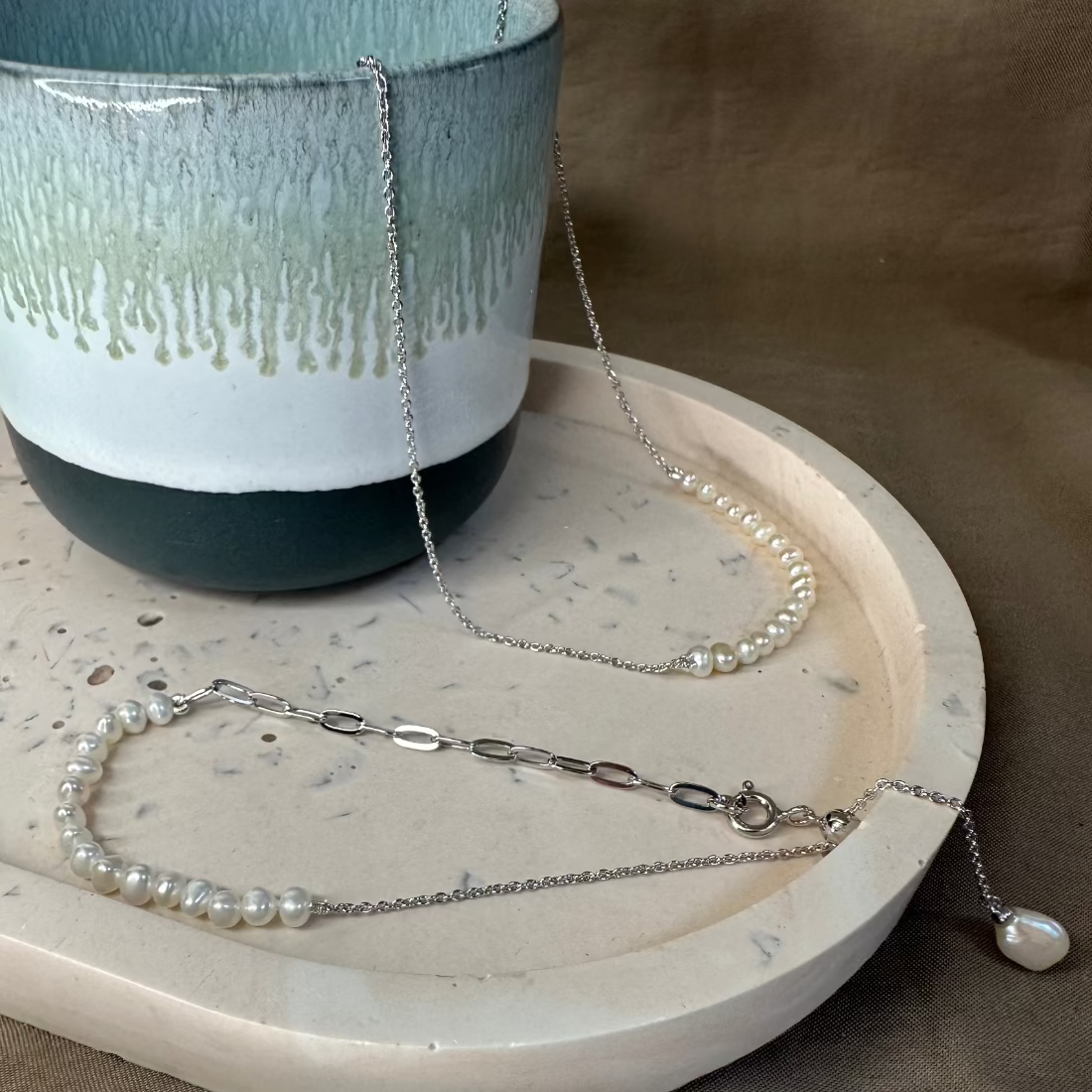 freshwater pearl necklace and matching bracelet with trending silver paperclip chain resting on ceramic dishes