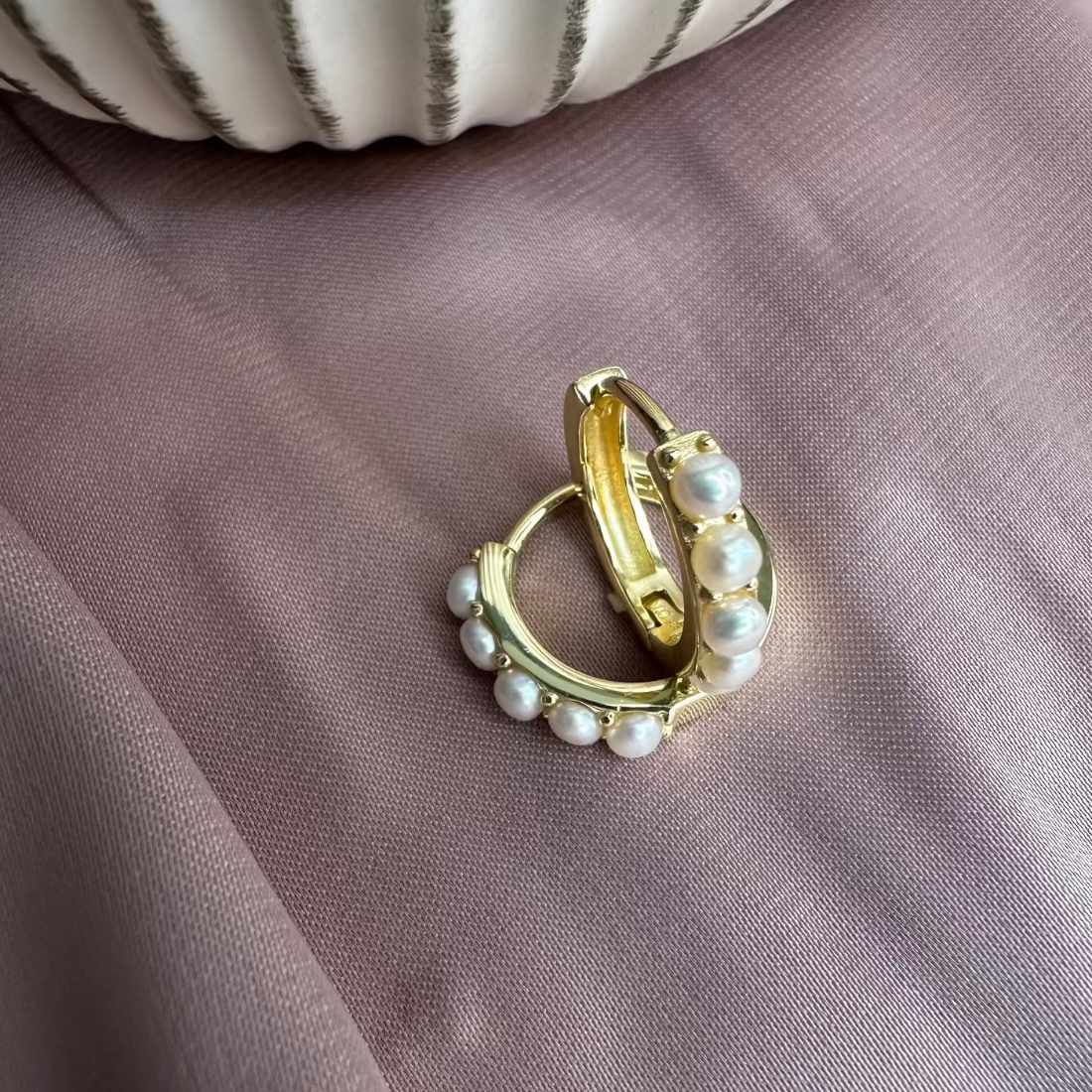 pair of pearl hoops set in modern style on pink ground