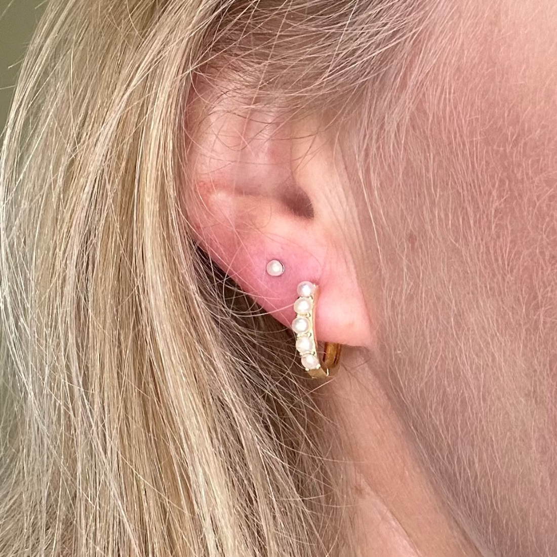 model wearing a pearl stud and a pearl hoop earring for a contemporary look with pearls