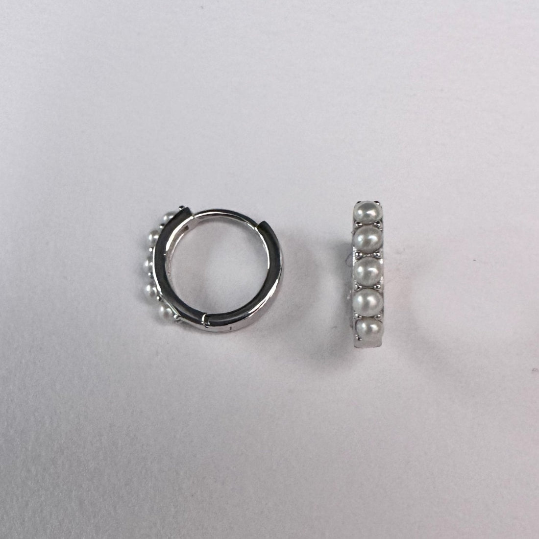 modern pearl set hoop earrings in silver set on white background