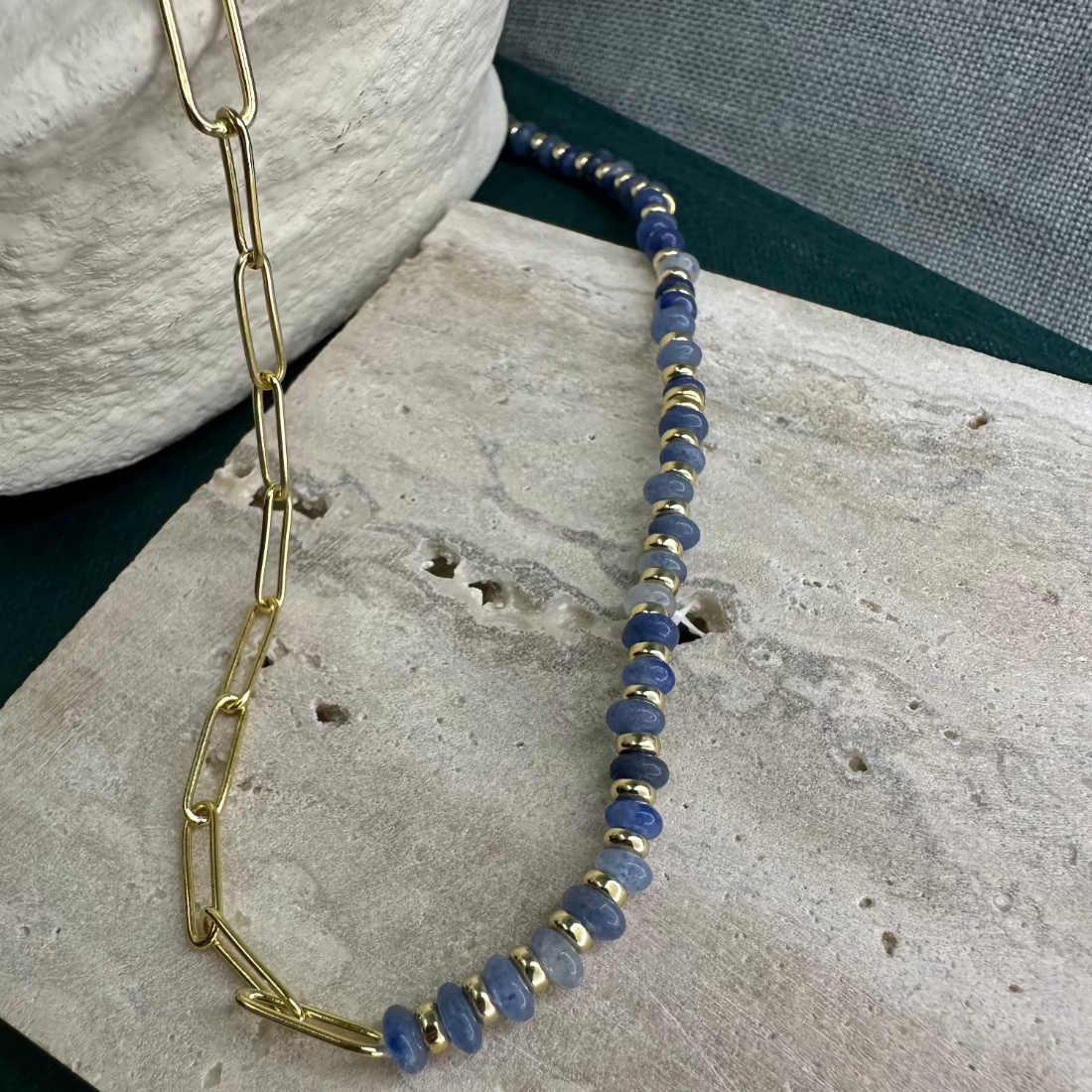 A modern paperclip linknecklace with a combination of African Jade stones and gold nugget beads displayed on a flat surface.