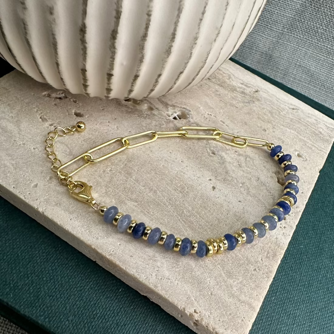 A gold and African jade stone bracelet with a paperclip chain design, displayed on a neutral surface.