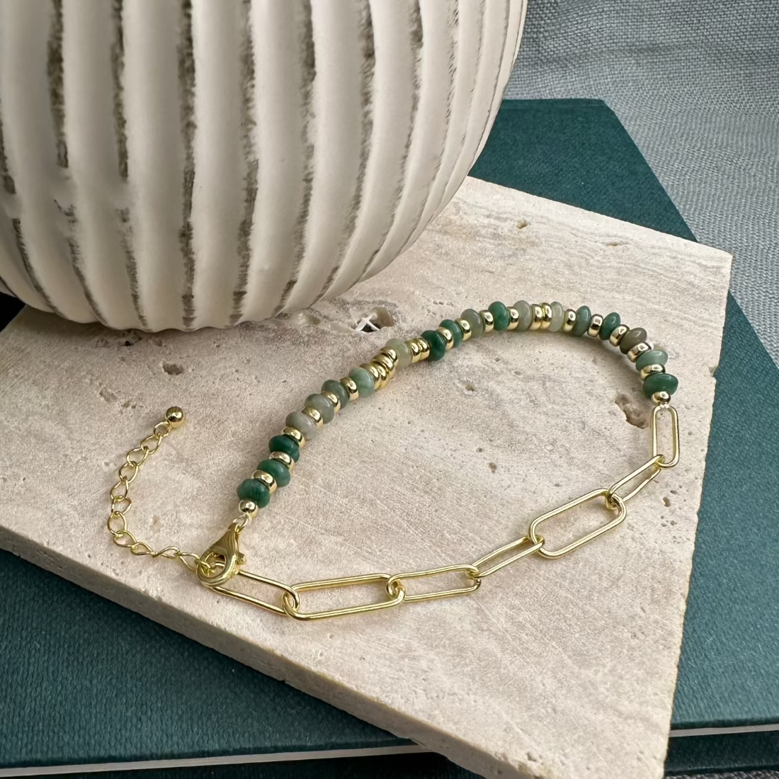 A gold and green African jade bracelet with a paperclip chain design displayed on a flat surface.