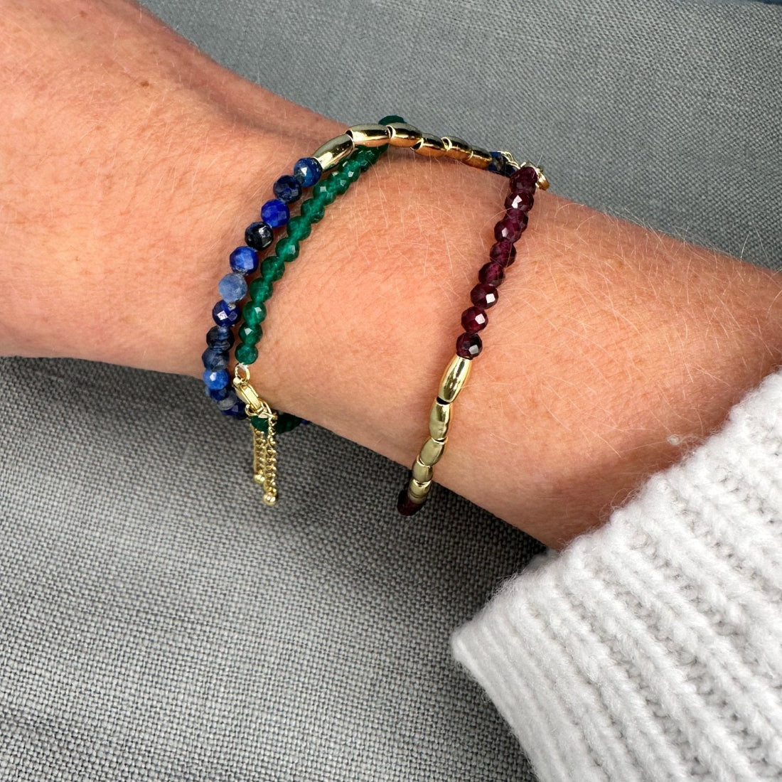 three gold nugget bracelet with green  red and blue sparkling cubic zirconia beads ideal for layering displayed on model wrist