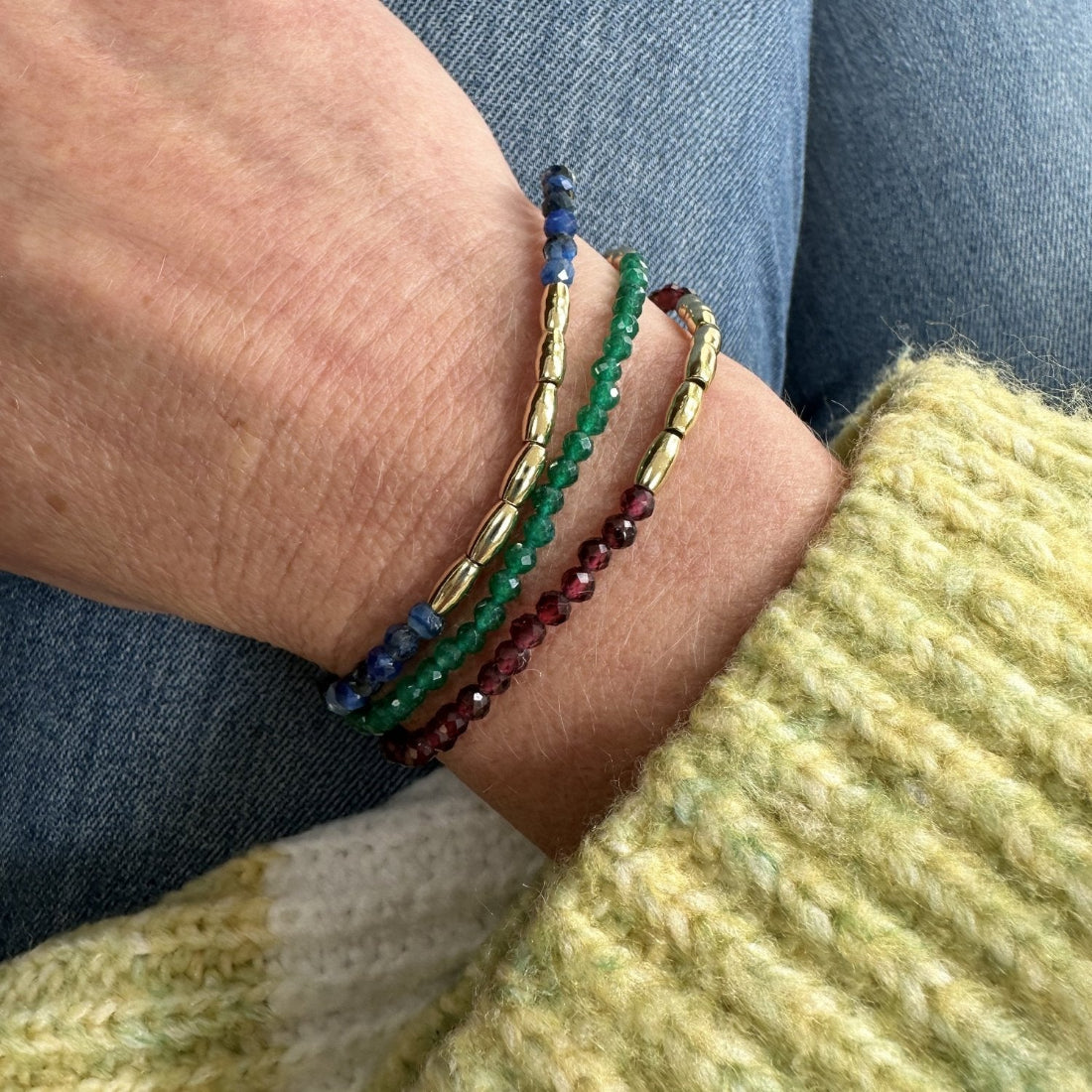 three gold nugget bracelet with green  red and blue sparkling cubic zirconia beads ideal for layering displayed on model wrist