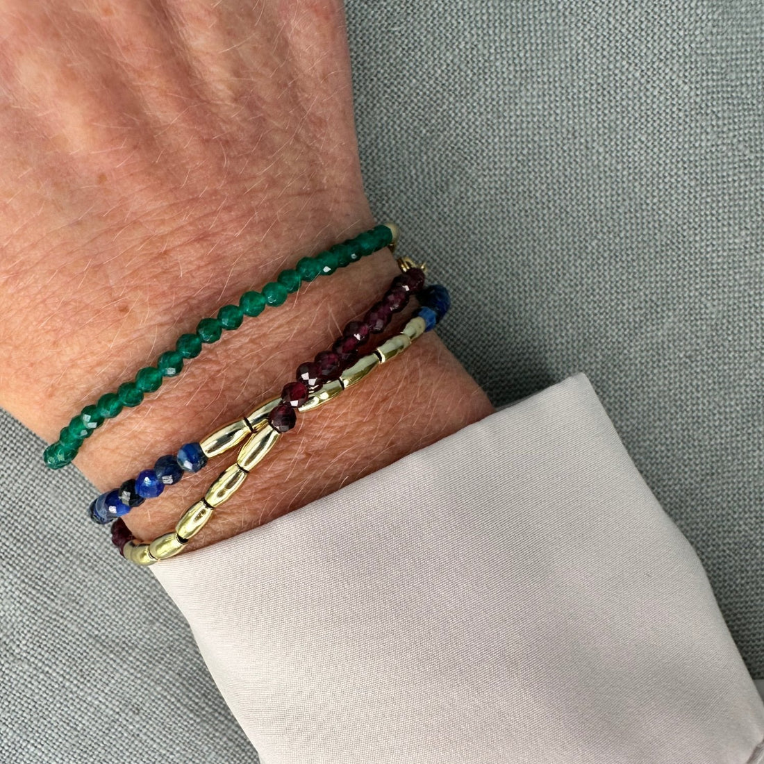 three gold nugget bracelet with green  red and blue sparkling cubic zirconia beads ideal for layering displayed on model wrist