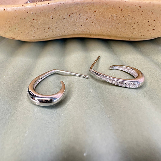 Silver hoop earrings on a textured surface